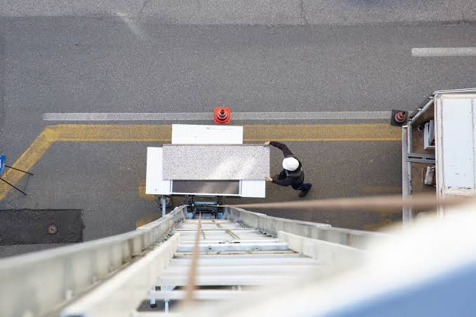Operatore Rotta Traslochi trasporta scatole con carrello